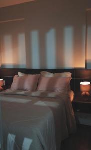 a bedroom with a bed with pillows and two lamps at S4 Hotel in Brasilia