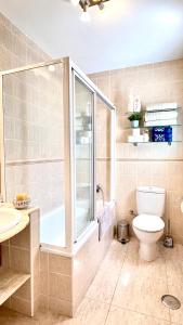 a bathroom with a shower and a toilet and a sink at Magnífico Ático 4 hab frente a la playa con piscinas parking incluido por keywise in Fuengirola