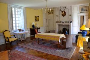 a living room with a table and a fireplace at Chambres d'hôtes Château de Bonabry in Hillion