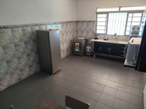 a kitchen with a refrigerator and a sink at Casa perto de Aparecida - Cantinho da Fé in Potim +2 photos
