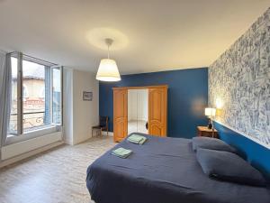 a blue bedroom with a bed and a large window at Hypercentral Champagne Nest in Épernay