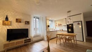 a living room with a television and a table with chairs at Hypercentral Champagne Nest in Épernay +28 photos