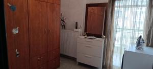 a kitchen with wooden cabinets and a dresser and a window at KilkisLuxuryApartment in Kilkis +27 photos