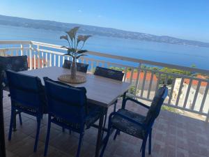 a table with chairs and a potted plant on a balcony at Villa Roing R in Stanići