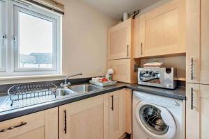 CamberにあるThe Beach House, Camber Sandsのキッチン(洗濯機、シンク付)