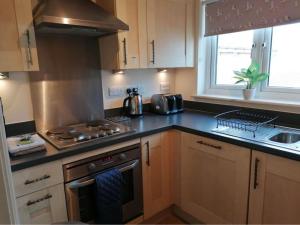 CamberにあるThe Beach House, Camber Sandsのコンロ付きのキッチン シンクの横にあるトップオーブン