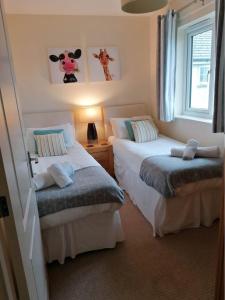 CamberにあるThe Beach House, Camber Sandsのベッド2台と窓のある寝室 +16枚の写真