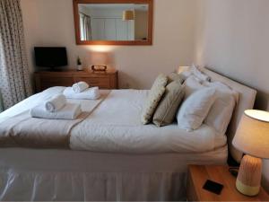 CamberにあるThe Beach House, Camber Sandsのタオルが敷かれた白いベッドのある寝室