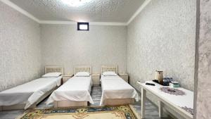 a hospital room with three beds and a table at Saidi Silk Road Family Guest Room in Samarkand +46 photos
