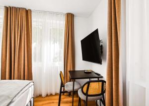 a room with a table and two chairs and a television at Limehome Karlsruhe Kaiserstraße in Karlsruhe