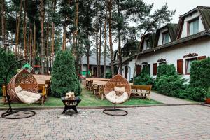 a patio with chairs and a table and trees at Karczma Rzym Bydgoszcz S5 in Bydgoszcz