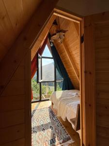 an attic bedroom with a bed and a window at MOSES HOUSE-მოსეს სახლი in Baladzeyebi