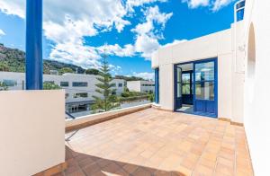 a balcony of a white building with blue doors at Villa Lucentum in Alicante