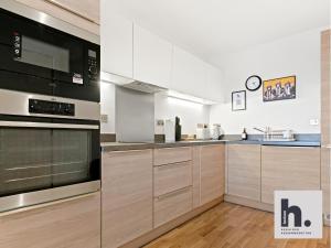 eine Küche mit Küchengeräten aus Edelstahl und Holzschränken in der Unterkunft Free Parking - Balcony - Siemens - Perfect for Business & Weekends x6 Units in Hull