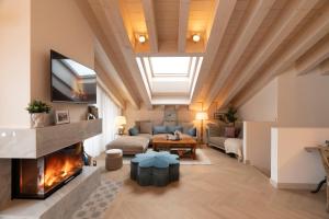 ツェルマットにあるLe Mirabeau Resort & Spaのソファと暖炉のあるリビングルーム
