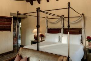 a bedroom with a large canopy bed with white pillows at Las Casitas, A Belmond Hotel, Colca Canyon in Yanque +55 photos