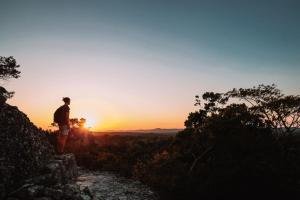 a man standing on a hill watching the sunset at Hotel Villa del Lago in Flores
