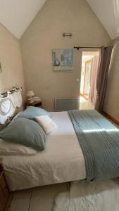 a bedroom with a large bed and a window at L'Orme Seul, Gîte in Vineuil