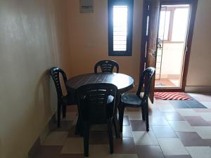 a table and chairs in a room with a window at Coorg villa homestay in Madikeri