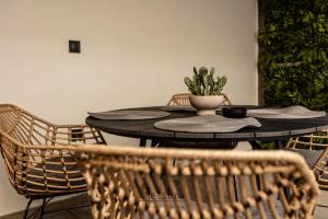 a black table with chairs and a plant on it at Meliora in Nea Artaki