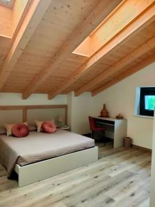 a bedroom with a bed with red pillows and a desk at Casa Cuor di Castagno in Roncegno