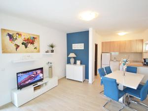 a living room with a television and a table and chairs at Holiday Home Sunset in Zadar