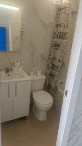 a white bathroom with a toilet and a sink at tenerife only rooms near to beach in Los Cristianos