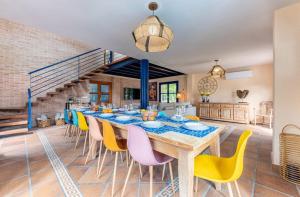 a dining room with a long table and yellow chairs at Villa Lucentum in Alicante