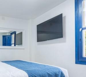 a bedroom with a flat screen tv on the wall at Villa Lucentum in Alicante