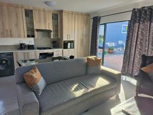 a living room with a couch and a kitchen at Sir James Self Catering in Cape Town
