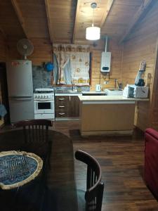 a kitchen with a refrigerator and a stove at Casa Lelikelen dos dormitorios in Caburgua