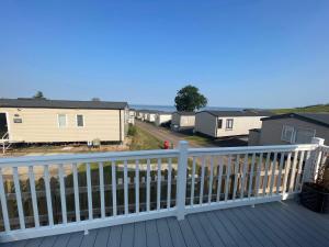 Una terraza con vista a una hilera de casas móviles. en Ladram Bay Holiday Park D82, en Otterton