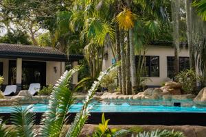 a house with a swimming pool and palm trees at B&B Sawubona in Mtubatuba