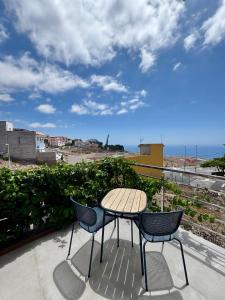 ein Tisch und Stühle auf einem Balkon mit Blick auf das Meer in der Unterkunft Casa Felipe 5 in Tijoco de Abajo