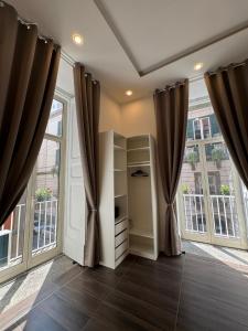 een kamer met grote ramen en gordijnen bij Kairos Relais in Napels