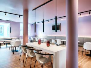 a dining room with tables and chairs and a tv at B&B Hotel Eisenach in Eisenach