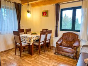 a dining room with a table and a leather chair at Villas Hidden Paradise in Žabljak +11 photos