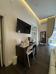 een woonkamer met een bureau en een tv aan de muur bij Kairos Relais in Napels +63 foto's