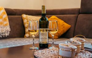 a bottle of wine and two wine glasses on a table at Villas Hidden Paradise in Žabljak