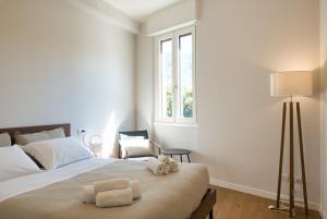 a bedroom with a bed with two towels on it at Wake of the lake - bright waterfront apartment in Lecco