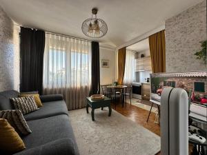 a living room with a couch and a fireplace at Prishtina Center Apartment in Pristina