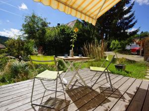 Ein Tisch und zwei Stühle auf einer Terrasse mit einem Sonnenschirm in der Unterkunft Biber Lodge in Feldberg