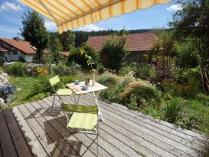 Ein Tisch und Stühle stehen auf einer Holzterrasse. in der Unterkunft Biber Lodge in Feldberg