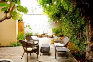 a patio with a bunch of chairs and tables at The Marlowe Seaside Villa in Santa Barbara
