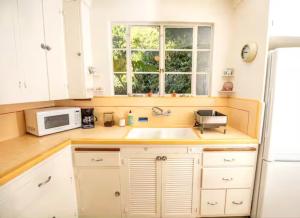 a kitchen with a sink and a microwave at The Marlowe Seaside Villa in Santa Barbara