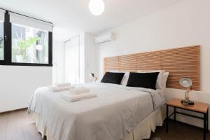a bedroom with a large white bed with a large window at Fliphaus SantaFe 3 Bd Pool & BBQ Palermo Hollywood in Buenos Aires +8 photos