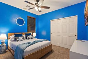 - une chambre bleue avec un lit et un ventilateur de plafond dans l'établissement Chill & Thrill | Pool, Hot Tub • Family Game Villa, à Casa Grande 106 autres photos