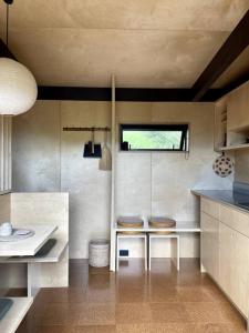 Una cocina con un fregadero y dos taburetes. en Whare Totahi, en Raglan