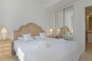 a bedroom with a large white bed with towels on it at Casa Del Mar in Zahara de los Atunes +15 photos