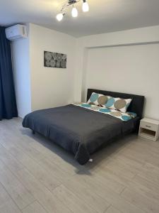 a bedroom with a black bed with pillows on it at Oma Ra in Ocna-Mureşului